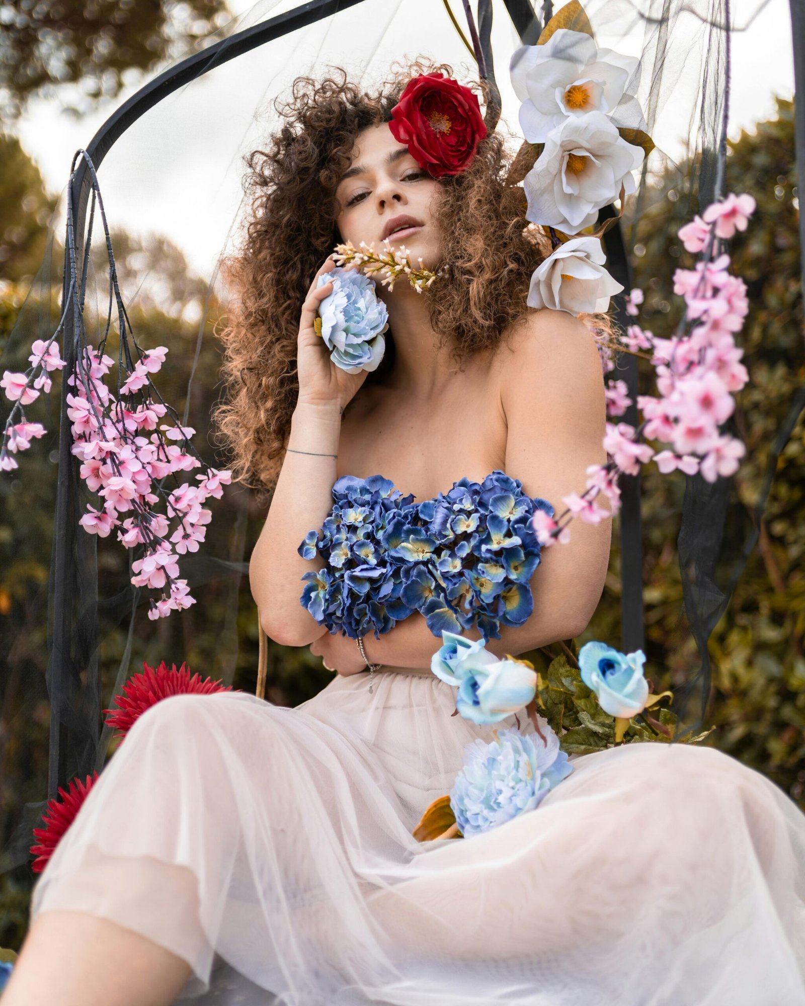 Stunning portrait of a woman surrounded by vibrant flowers and natural colors.